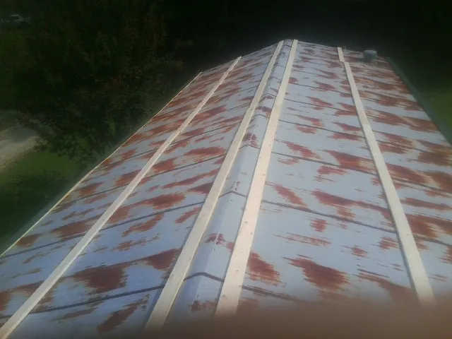 Rusted metal roof panels with new wood purlins before replacement — Storm Damage Roof Repair in Oskaloosa by Roofing Brothers